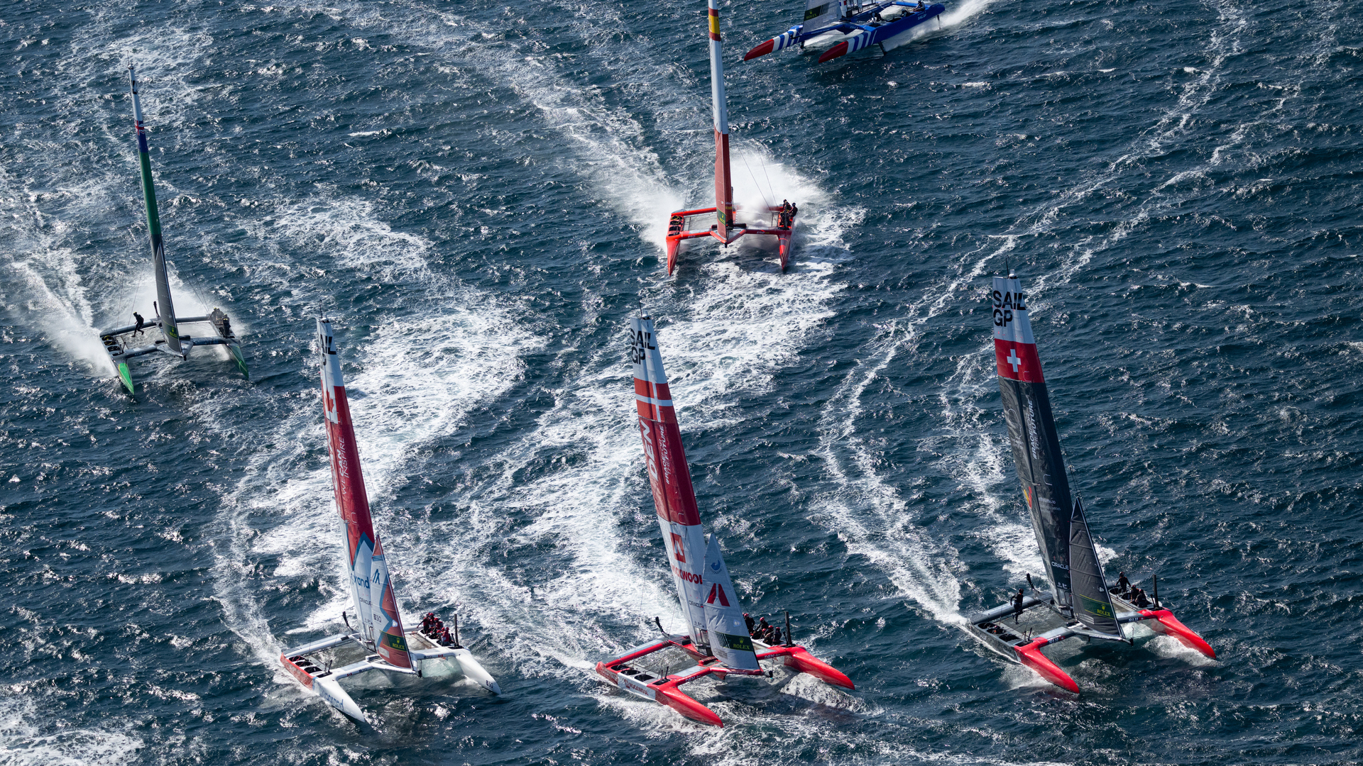 The tightly packed SailGP fleet racing on rough waters in Saint-Tropez.